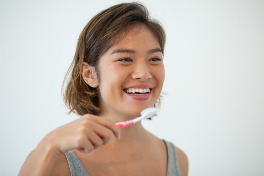 smiling-pretty-asian-woman-brushing-teeth (Large)