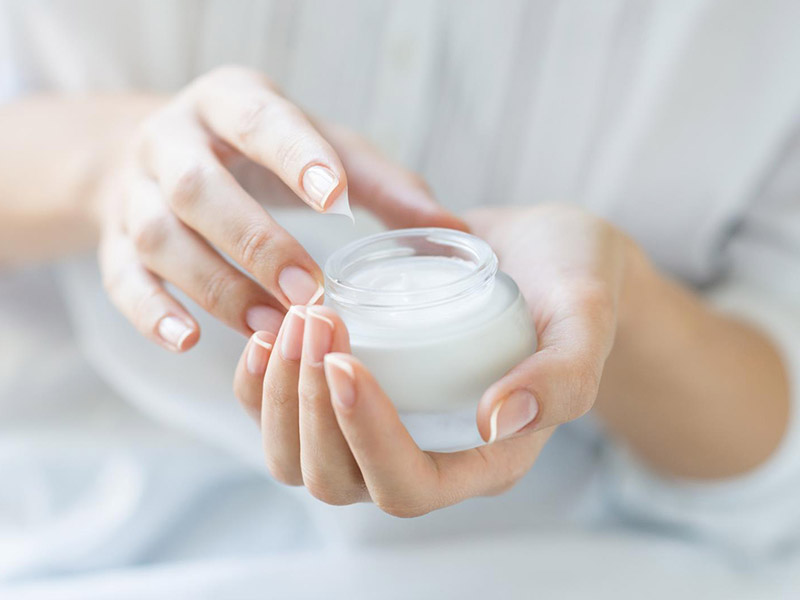 woman holding skin care cream